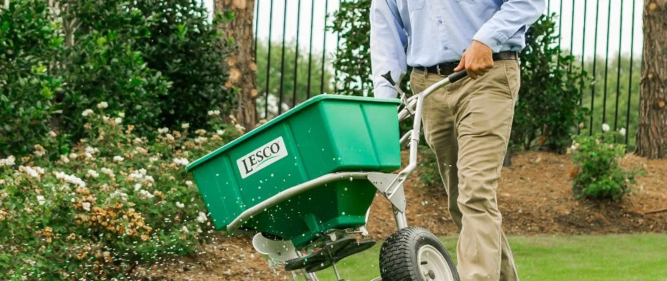 Weedex employee fertilizing a lawn in Dallas, TX.