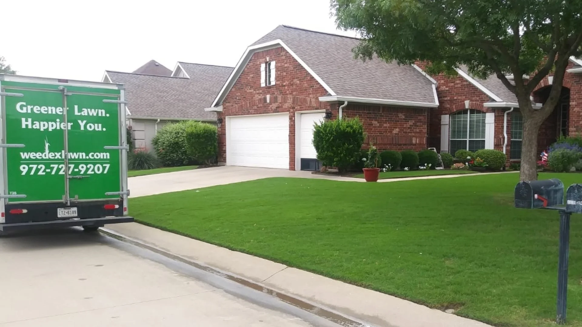 Green truck parked in front of a house with a lush, well-maintained lawn in Forest Hill, TX