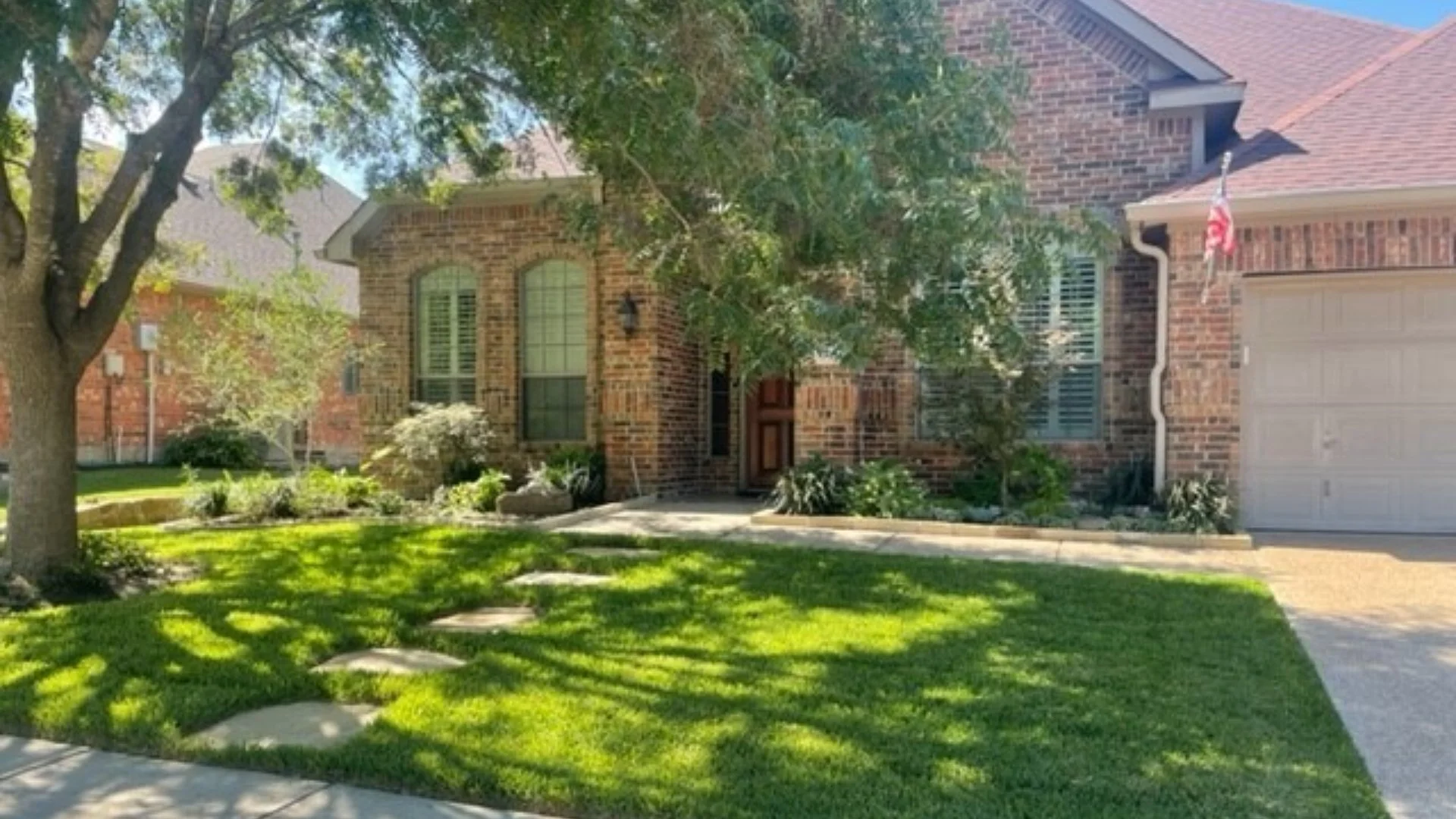 Front yard, dense green lawn with trees in Irving, TX.