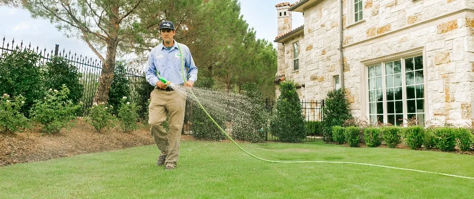 Crew applying a liquid fertilizer treatment on a lawn in Dallas, TX.