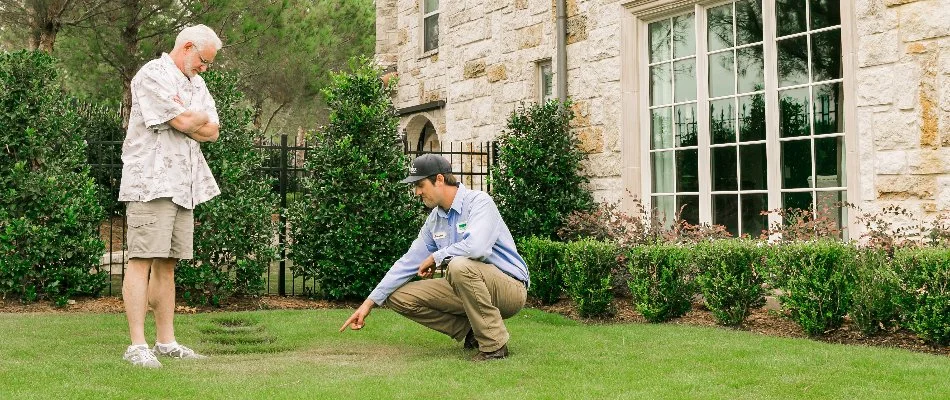 Employee showing lawn disease to client in Dallas, TX.