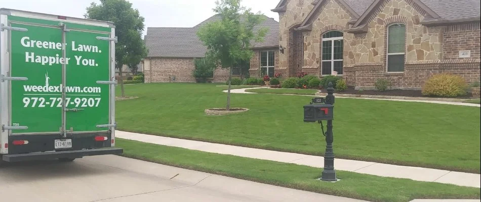 Green lawn and work truck in street in Dallas, TX.