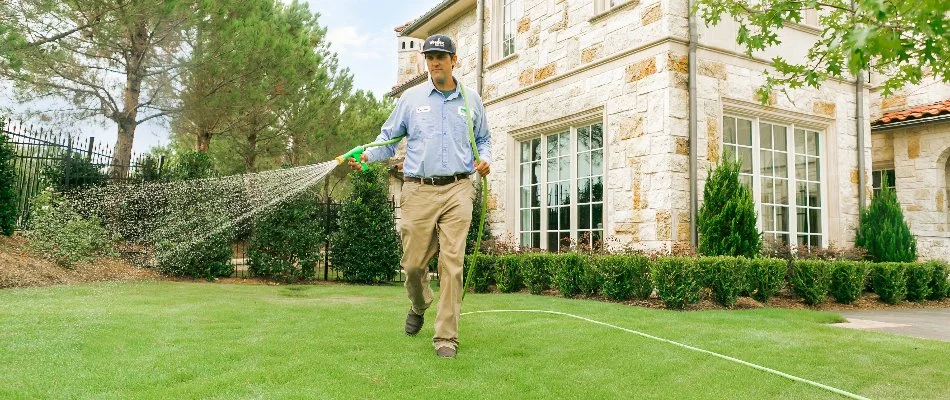 Crew applying liquid fertilizer on grass in Dallas, TX.