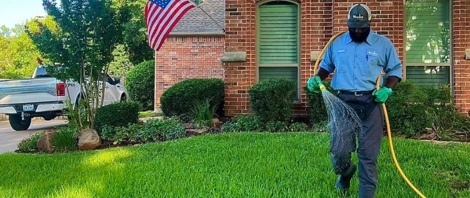 Worker performing a lawn care service on a property in Lake Dallas, TX.